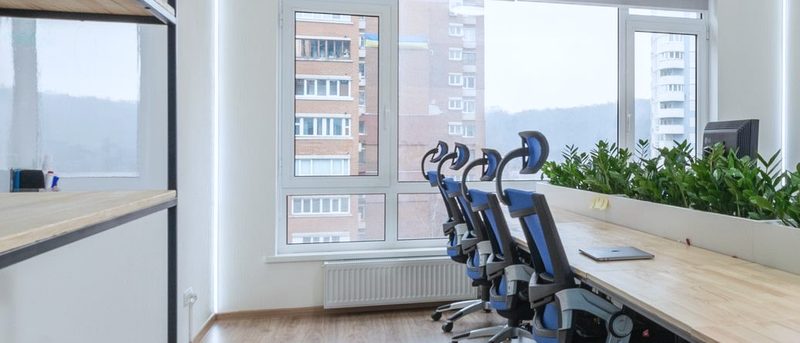 A bright small-business office with a long desk next to the windows