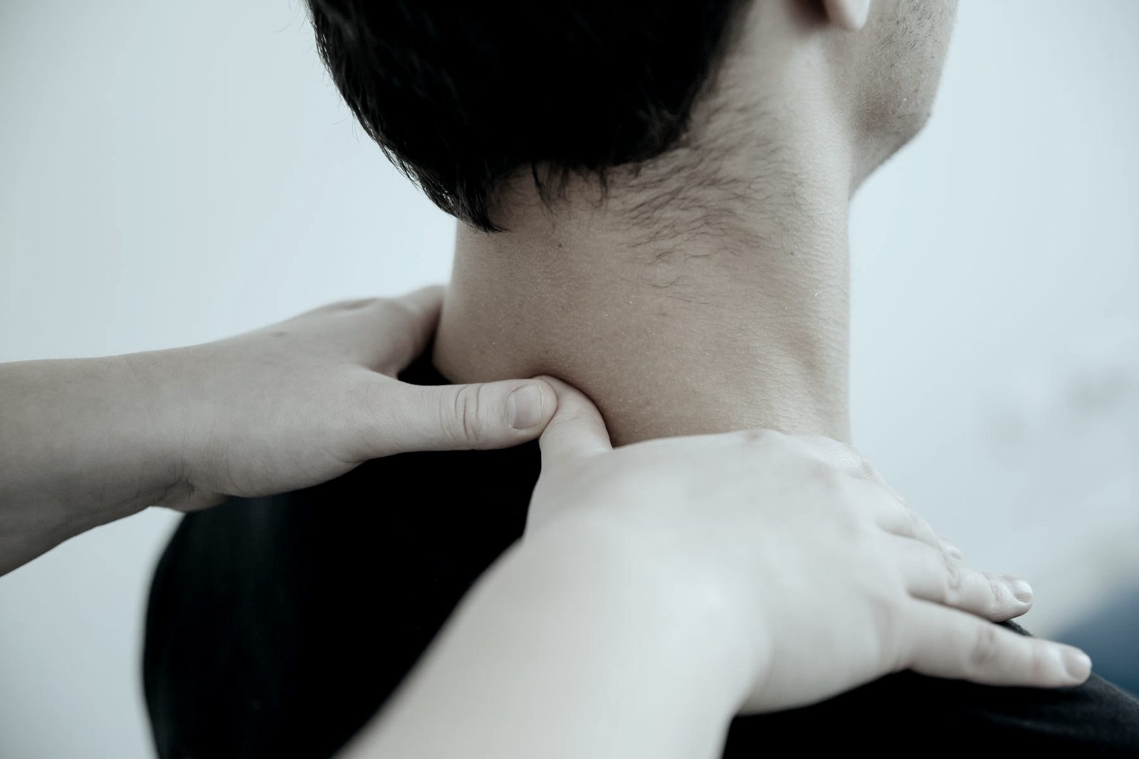 Manos de fisioterapeuta sobre cuello y hombro, fotografía de ambiente
