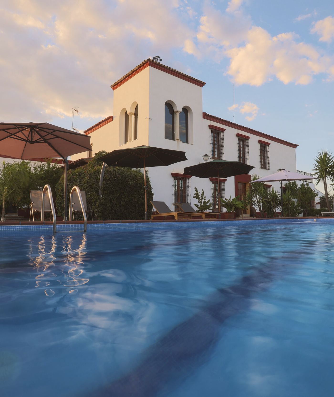 La piscina de agua salada y, detrás, el torreón encalado del cortijo con sus ventanas en arco