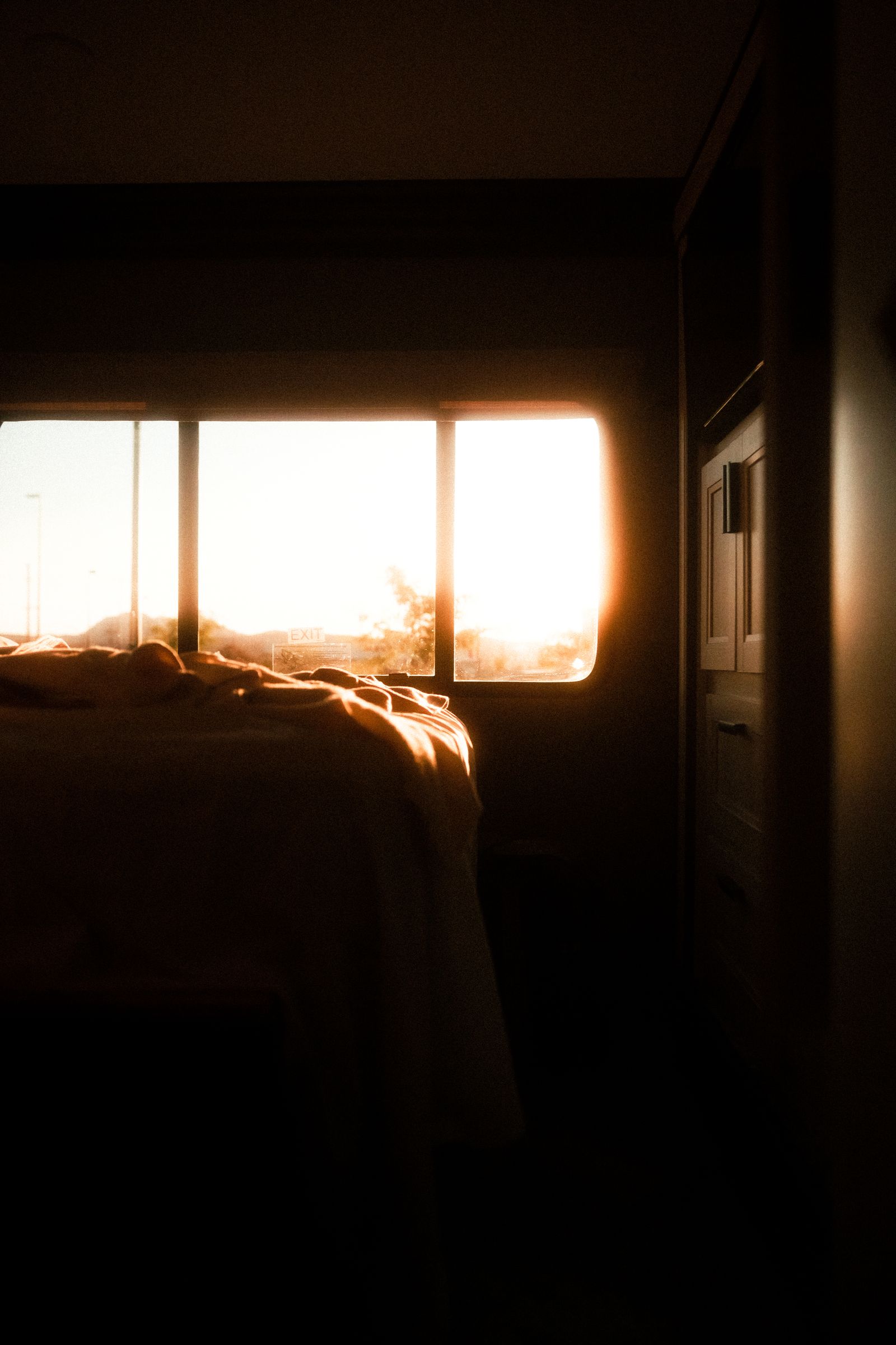 Cama con la luz dorada del final de la tarde entrando por la ventana